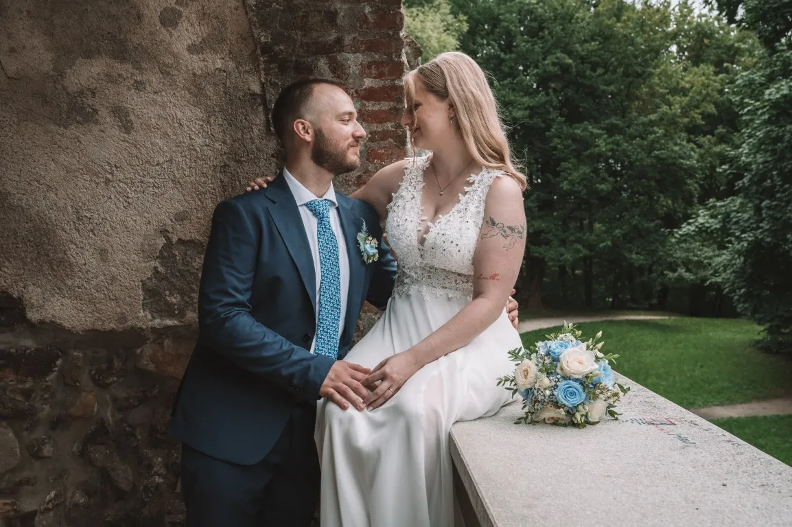 Poročna fotografija mladoporočencev; ujet pristen trenutek z naravno svetlobo in umirjeno kompozicijo v dokumentarnem slogu.